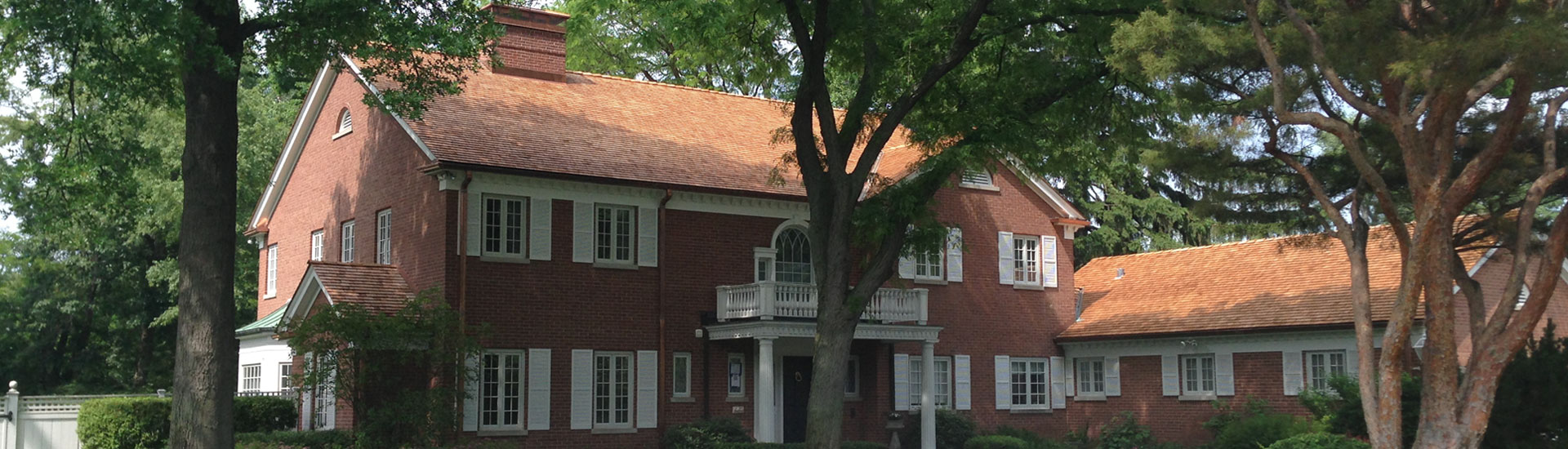 Large residential home with a custom asphalt roofing job completed by Hanson Roofing